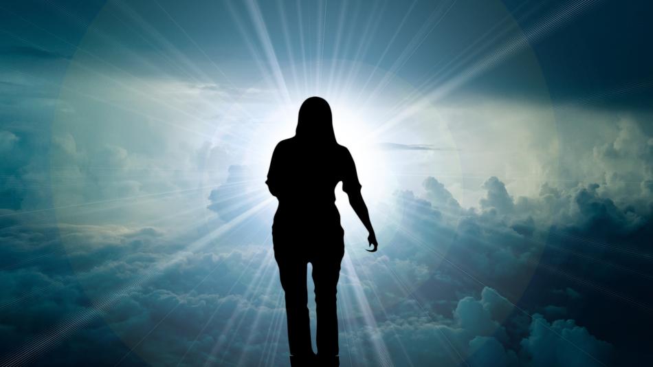 silhouette of a girl on a background of solar glow in the sky