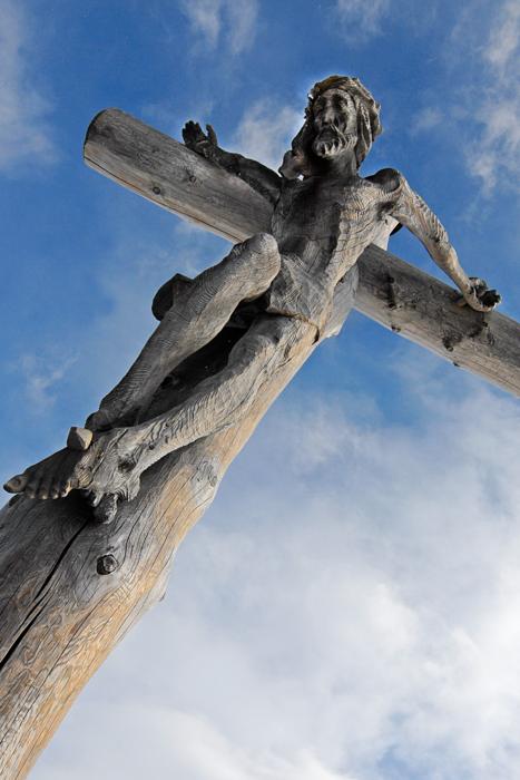 wooden cross with jesus on the background of the sky with clouds