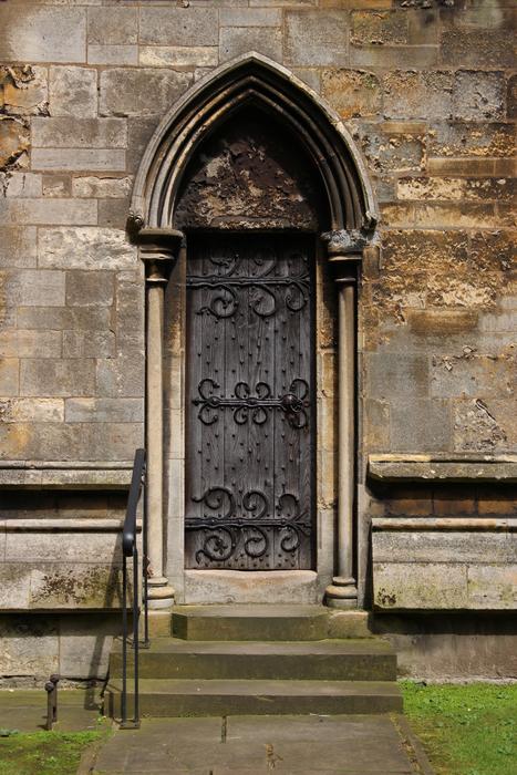 photo of a wooden door with wrought iron elements in a gothic cathedral