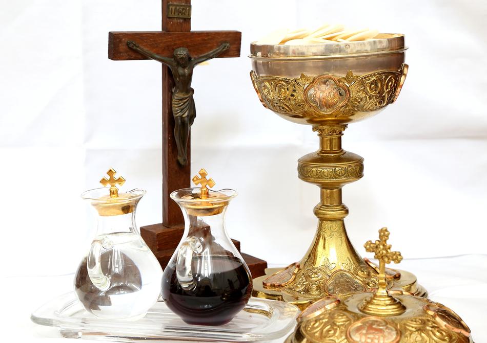 wine and water in front of Crucifix and golden Chalice