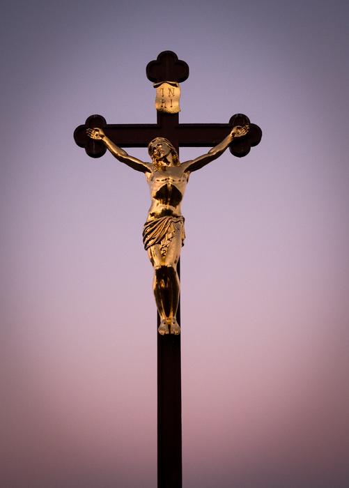 jesus christ on the cross against the background of the evening sky