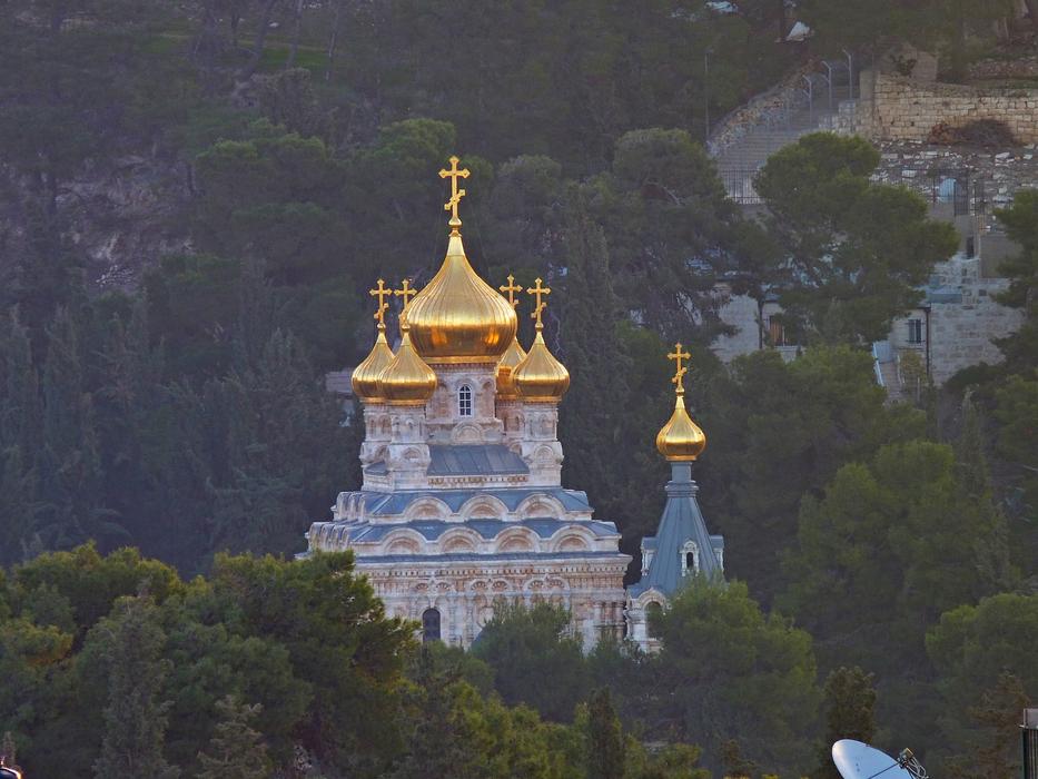 panoramic view of the temple with gold domes among the trees on the mountain