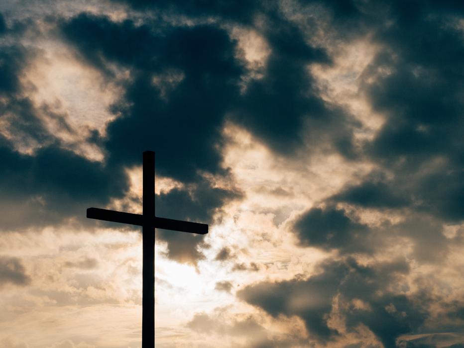 Summit Cross at dark dramatic clouds