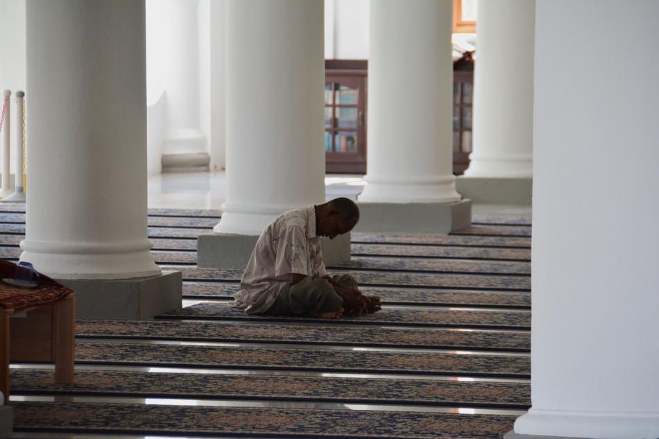Praying person on steps of Mosque