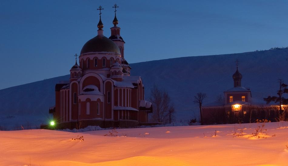 church with domes among the snowy landscape at night
