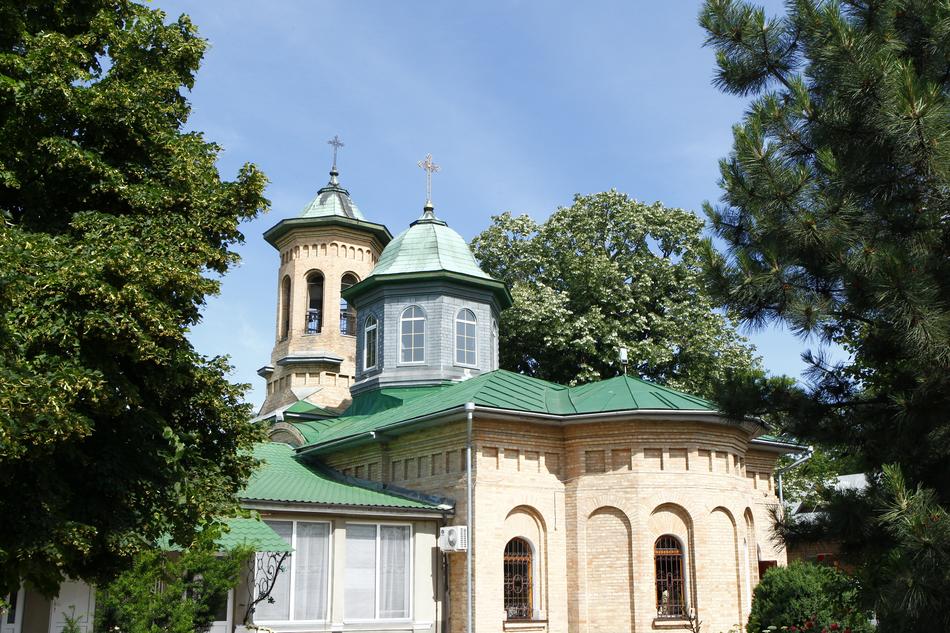 Beautiful monastery with green domes among the plants