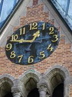 golden clock on the facade of the church