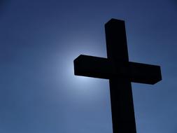 wooden cross on the background of the sun in the sky