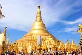 Beautiful, shiny, gold Shwedagon Pagoda, at blue sky with white clouds on background, in Yangon, Myanmar