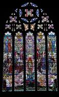 Beautiful and colorful, patterned stained cathedral window, in the church, among the darkness