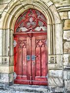 red wooden front door in the church building