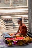 Buddhist monk sits near a temple on the street