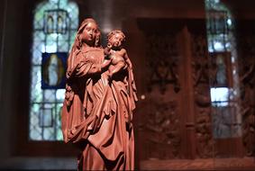 medieval statue of a woman with a child in a church on a blurred background
