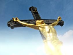golden crucifix against blue sky
