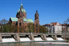 Beautiful and colorful Luke's Church, on the shore of the water in Munich, Germany, at blue sky on background
