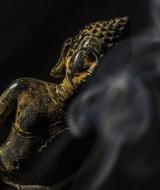 Beautiful, yellow Buddha statue and white smoke