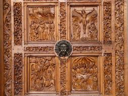 carved wooden door depicting the crucifixion of Jesus