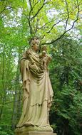 statue of the mother of God on the background of the forest