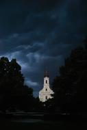 dark storm over white church building