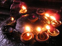 Beautiful, red, orange and yellow burning prayer candles in the temple in Madurai, India