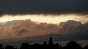 dark clouds during a thunderstorm over the trees