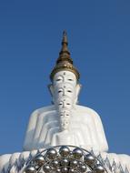 huge white buddha statue against the blue sky