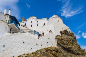 People near the beautiful white church on Skopelos in Greece