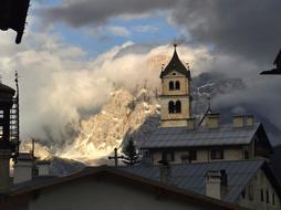 Beautiful church, among the white clouds, on the snowy mountains in South Tyrol, Italy