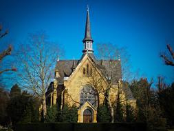 Beautiful church, among the trees, under the beautiful, gradient, blue sky
