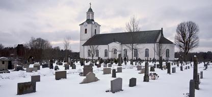 Graveyard near old Church at winter evening