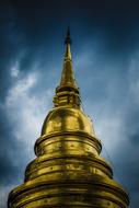 Beautiful gold Wat Suan Dok pagoda at cloudy sky