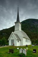 white wooden church with graveyard