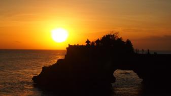 Temple on coast at orange Sunset