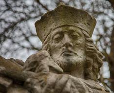 Beautiful statue of the Saint Nepomuk in Nepomuk, Cezch Republic, at background with the branches