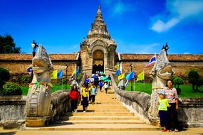 tourists on the stairs in front of the pagoda in thailand