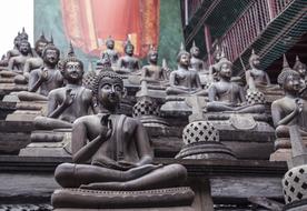 Beautiful statues of Buddha, near the colorful and beautiful painting