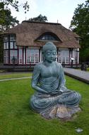 Beautiful, green Buddha sculpture, near the Japanese Home with the garden