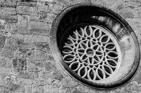 round window on the stone facade of the old church