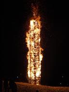burning wooden post in the dark