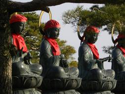 Beautiful, green and red Buddha statues, near the green trees