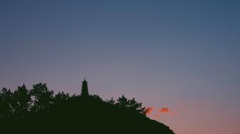 Silhouette Building on hill at sunset