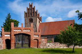 Beautiful and colorful church, among the green plants, under the blue sky with white clouds, in Germany