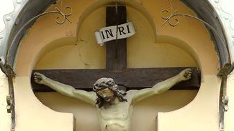 sculpture of jesus christ on the cross near the wall