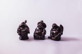 three buddha figurines as talismans