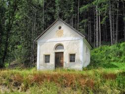 church with white walls near the forest