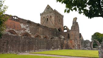 Beautiful and colorful church ruins in Scotland, among the colorful and beautiful plants, on the landscape