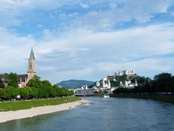 Beautiful Evangelische Christuskirche on the shore with green plants in Salzburg, Austria