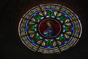 round stained glass window in church with sunlight