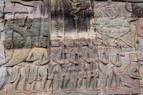 carvings of warriors on a temple wall in cambodia