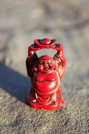 red buddha figurine on blurred background